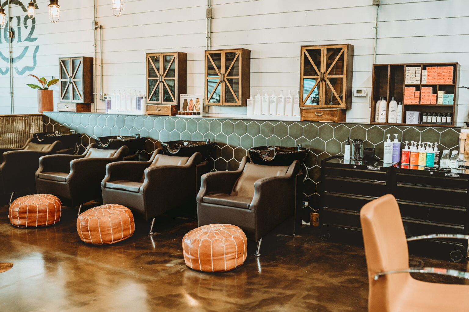 Shampoo chairs beneath the 11612 sign at The Refinery Hair Lounge in Middletown