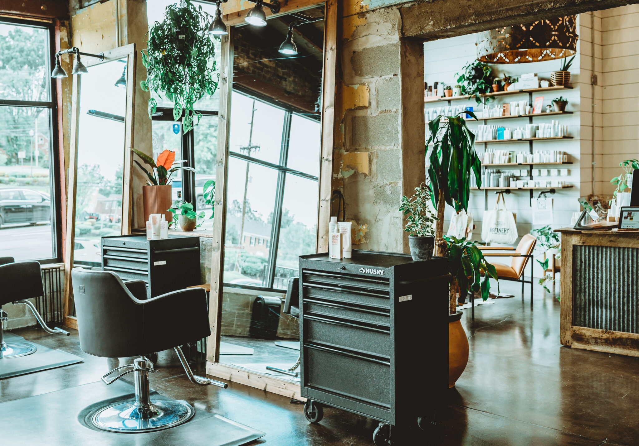 Bright styling station with plants and product shelves at The Refinery Hair Lounge in Middletown