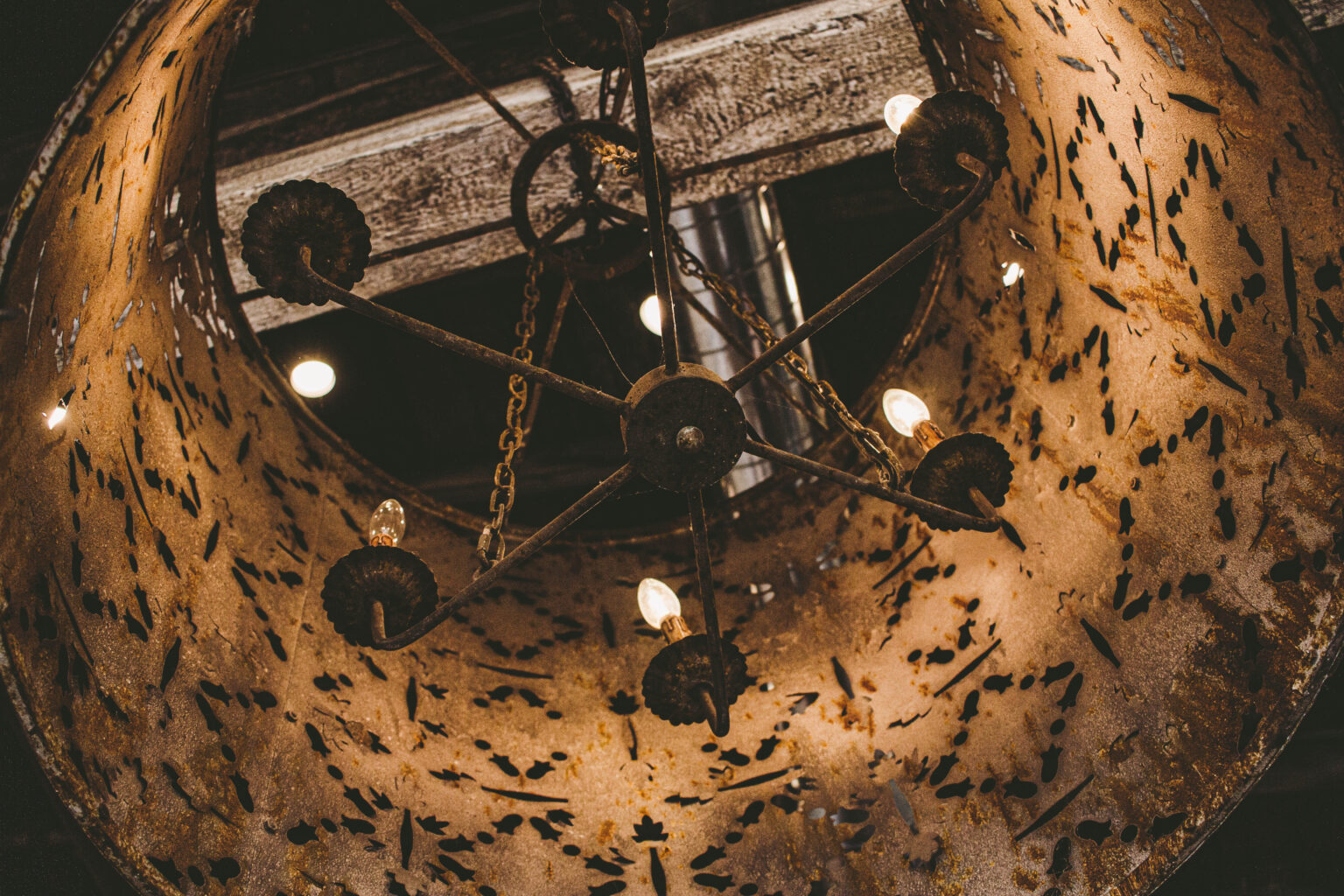 Wrought-iron chandelier hanging from the ceiling of The Refinery Hair Lounge